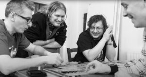 Designers at board game publisher Czech Games Edition including Vlaada Chvatil sit around a table playing a game