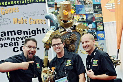 The Game Crafter founders JT Smith, Tavis Parker and Jamie Vrbsky posing with a large robot
